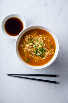 Overhead Image Of Easy Japanese Ramen With Noodles, Pork Broth, Egg And Leek In White Bowl On Concrete Background