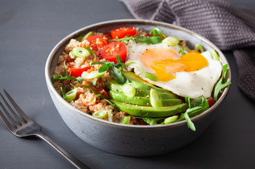 quinoa bowl with fried egg, avocado, tomato, rocket. Healthy vegetarian lunch