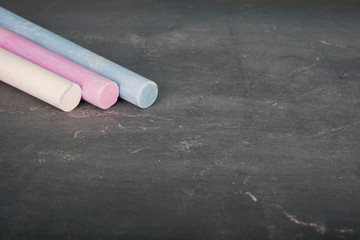 Coloured chalk over chalkboard. Selective focus