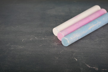 Coloured chalk over chalkboard. Selective focus