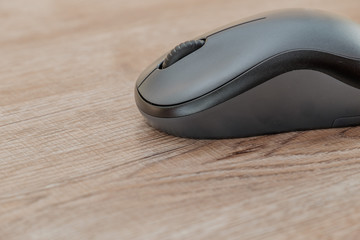 black computer mouse on wooden foor.