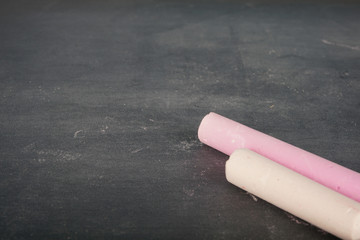 Coloured chalk over chalkboard. Selective focus