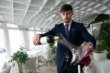 the young male sommelier while tasting red wine