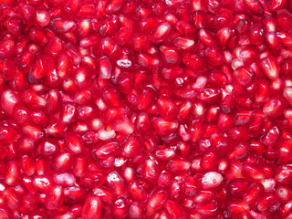 Background made of ripe pomegranate seeds, close-up. Red grains fruit punica granatum, top view. Pomegranate arils. Large size