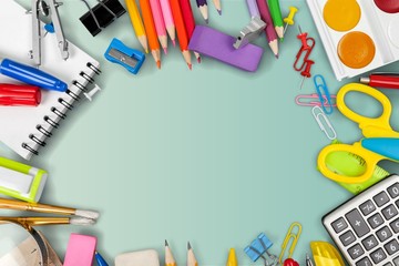 Colorful school supplies on blackboard background