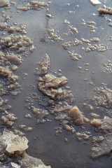 Frozen puddle on the road in winter