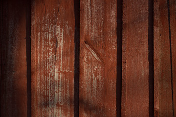 Texture of old wood with cracked paint of red color
