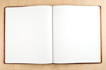 Blank open book on a wooden table