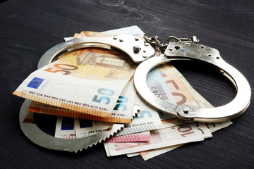 Handcuffs and euro banknotes. Penalty or fine in EU concept.