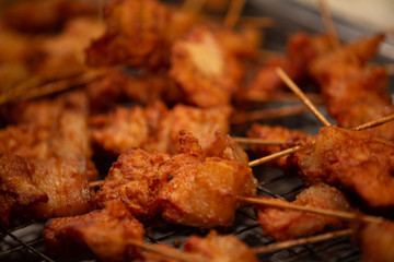 Close up Fried Pork stick on grid market, Thai cuisine traditional signature street food, quick delicious and easy eating, write copy space
