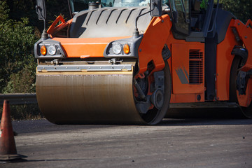 Carrying out repair works: asphalt roller stacking and pressing hot lay of asphalt. Machine repairing road