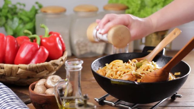 Indonesian pasta with chicken, pieces of bamboo and mushrooms.Seasoning, mixing, sprinkling and translating the dish.