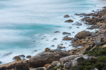 Fototapeta na wymiar Long exposure of rocks and waves at Little Oberon bay in Wilsons Promontory national park, Victoria, Australia