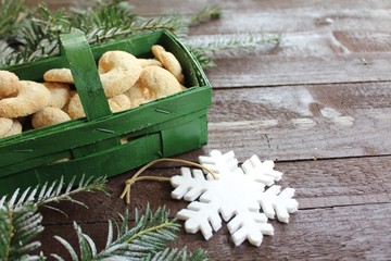 Vanillekipferl in einem grünen Körbchen und einer Schneeflocke