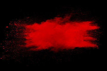 Red color powder explosion on black background.Freeze motion of red dust particles splashing.