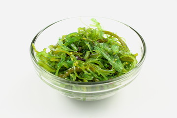 wakame salad with sesame in a small glass bowl isolated