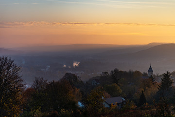 Vue sur un paysage de campagne en Lorraine avec ses collines et son village et son clocher au crépuscule