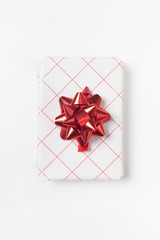 Close up of beautiful white red gift box on white background. Flat lay, top view