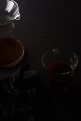 Pour over coffee in picther in two glasses on black background with black napkin. Overhead view