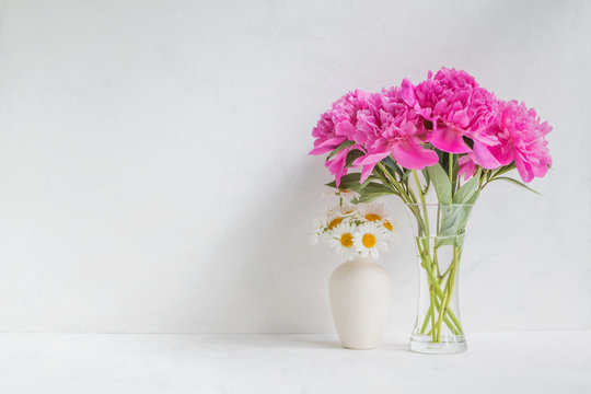 Pink peonies in a vase on a light background