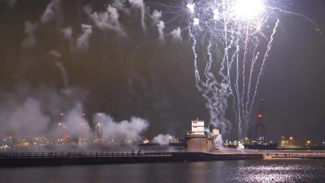 Ship passing (left side of frame) firework display at Fort Perch Rock on river Mersey mouth in Liverpool, England, United Kingdom at night