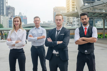 Portrait of four business colleagues doing confident gesture portrait at outdoor in city. Happy teamwork business professional leadership in suit. Looking camera