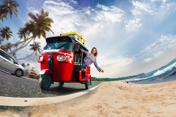 Happy woman travel by traditional srilankan transport, road near beautiful sea and plam