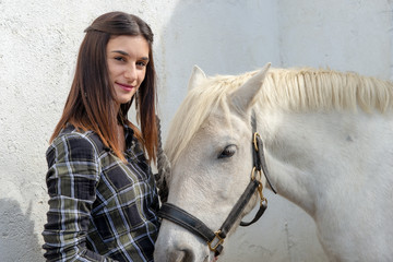 portrait of young rider woman with white horse