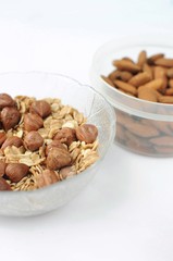 Food of a healthy lifestyle on white background. Flat view with copy space. Nuts, almonds and oatmeal. Food for fitness. Vegetarian food