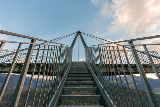 metal stairs lead up to an impressive lookout and viewpoint platform in the Grisons near Flims in Switzerland under a blue sky with white clouds