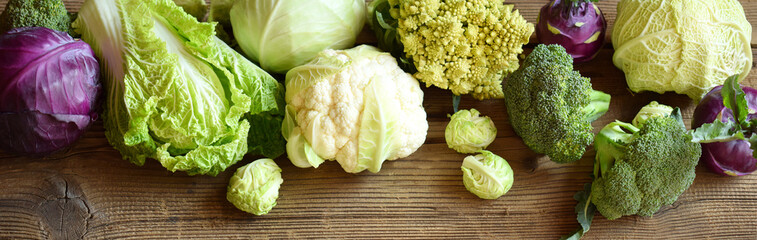 Different varieties of cabbages on wooden background. Organic fresh vegetables - cauliflower,...