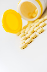 Pills and plastic bottle on the white table.