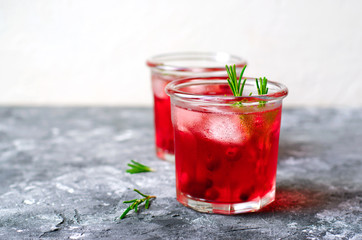 Cranberry Cocktail with Ice and Rosemary On Grey Background