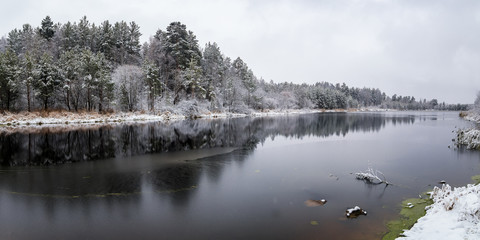 ноябрьский пейзаж на Уральском озере с заснеженным лесом на берегу озера, Россия, ноябрь