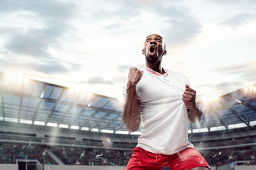 The football african player in motion on the field of stadium at day. The professional football,...