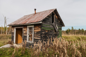 neglected cabin in a farmers field