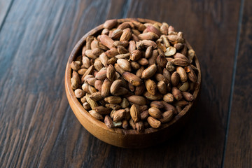 Organic Pistachio Nuts Without Shell in Wooden Bowl.