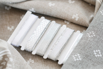 Silver ribbons on grey fabric.