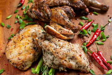 Grilled chicken laid out on a wooden board.
