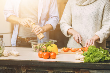 Lovely couple are talking and while cooking healthy food in kitchen at home. Close-Up.