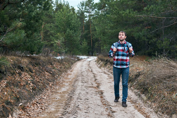 Fototapeta na wymiar Man walking in conifer forest
