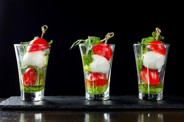 Canapes of tomatoes and cheese in a glass. Three cups.