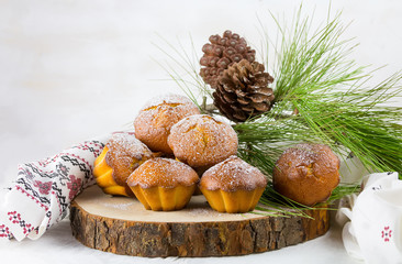 Homemade cristmas cupcake, christmas muffins and new yaer decoration on the white background and pine branches and cones
