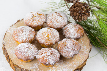Homemade cristmas cupcake, christmas muffins and new yaer decoration on the white background and pine branches and cones