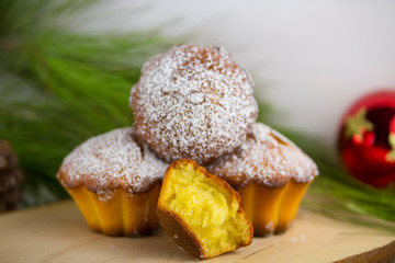 Homemade cristmas cupcake, christmas muffins and new yaer decoration on the white background and pine branches and cones