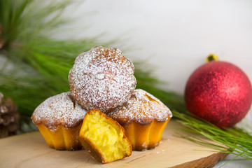 Homemade cristmas cupcake, christmas muffins and new yaer decoration on the white background and pine branches and cones