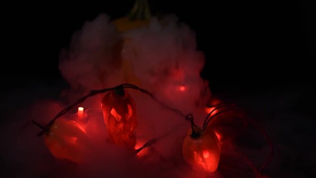 pepper jack o lanterns and a pumpkin with dry ice fog coming out dark photography