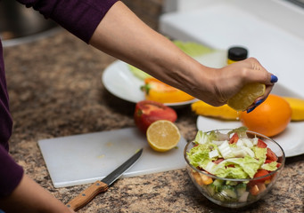 Female hand cuts vegetables for salad.