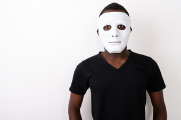 Studio shot of young black African man wearing mask