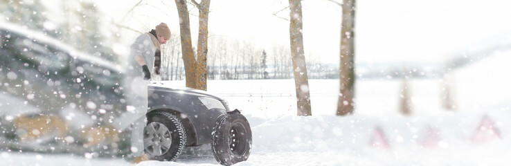 A man near a broken car on a winter day